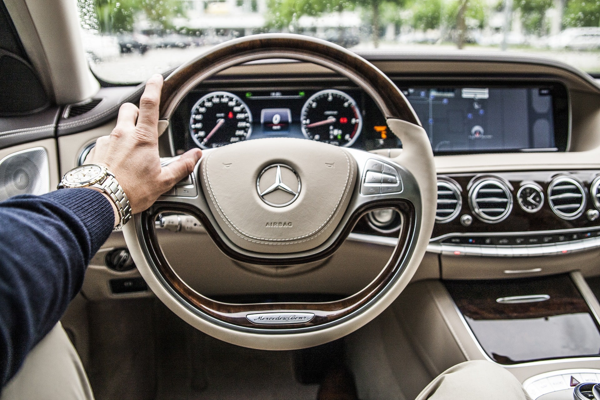 Aluguel de carros: Mão esquerda sobre o volante de um carro Mercedes
